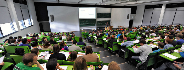 Students sit in a lecture hall in the seminar building at the Campus North.
